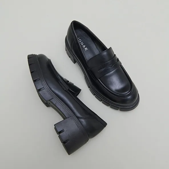 Heeled loafers with notched soles in black leather