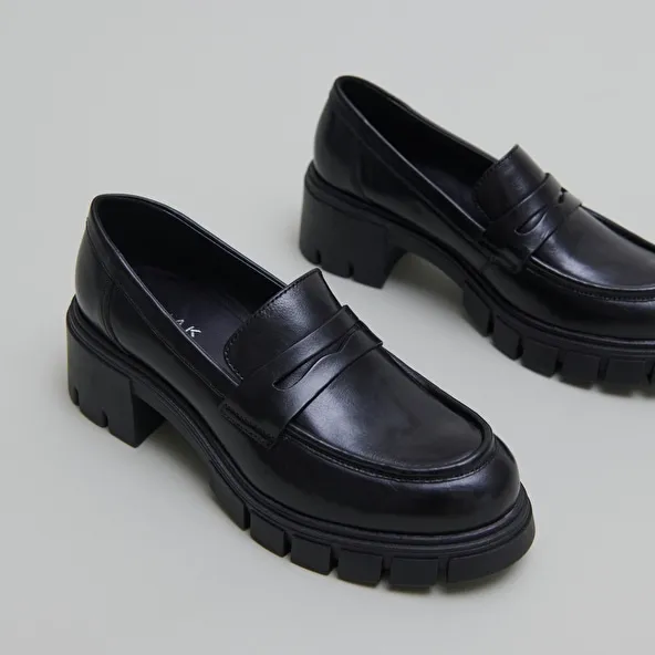 Heeled loafers with notched soles in black leather